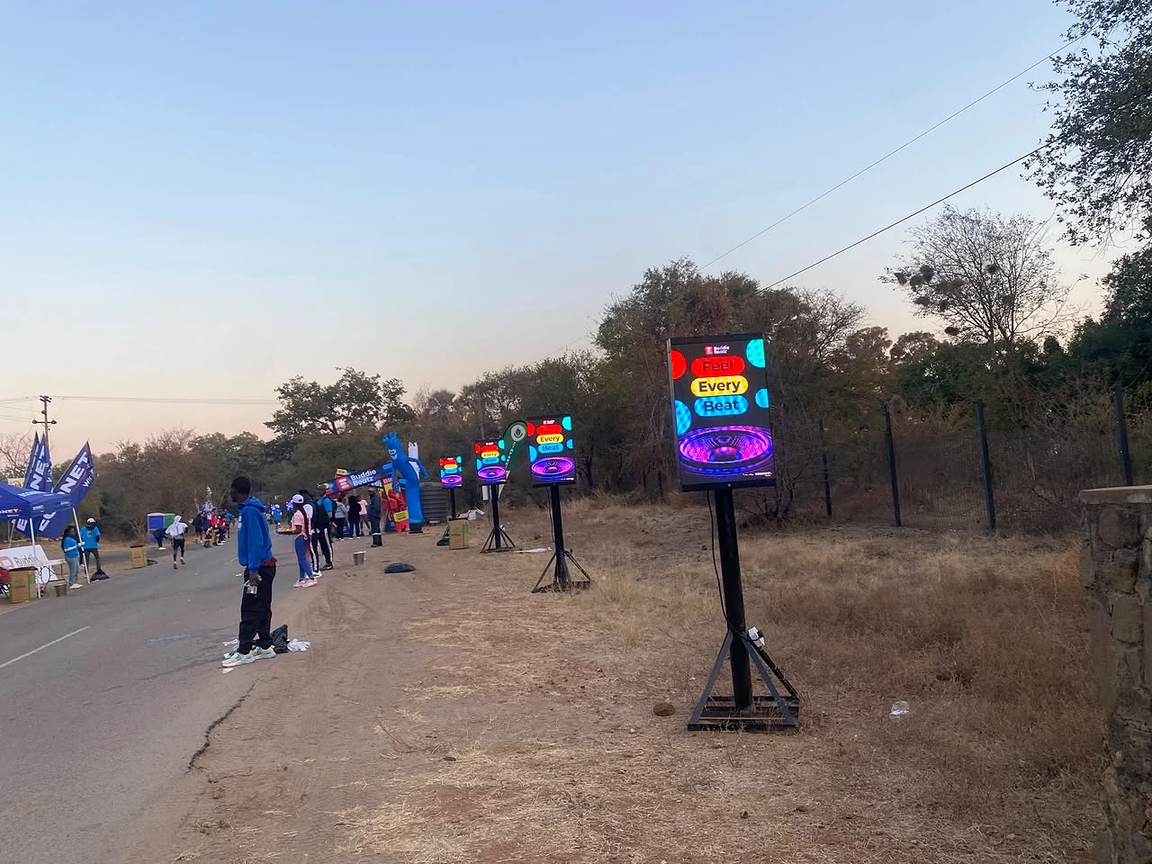 A sequence of illuminated digital event screens installed beside a road