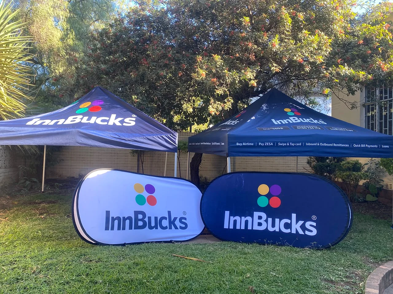 Two InnBucks branded pop-up tents with matching portable display banners
